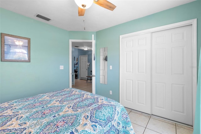 bedroom with ceiling fan, a closet, visible vents, and light tile patterned floors