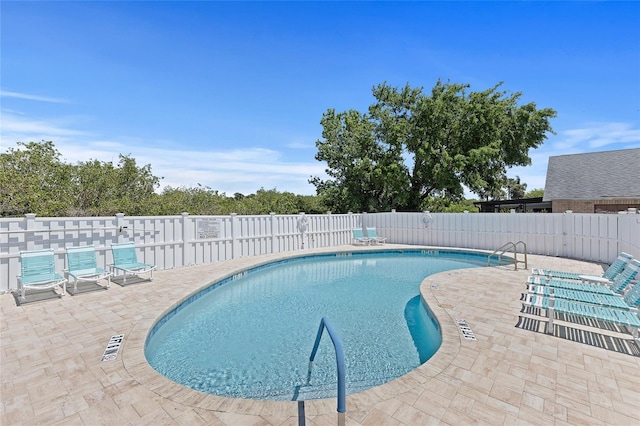 pool with a patio area and a fenced backyard