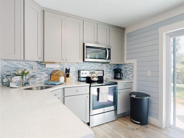 16 Hillside Dr, New Smyrna Beach, FL 32169 - kitchen with light countertops, a sink, stainless steel appliances, decorative backsplash, and gray cabinetry