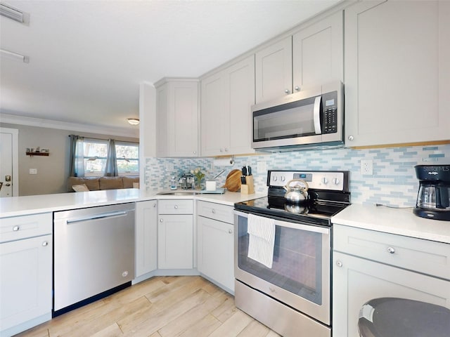 16 Hillside Dr, New Smyrna Beach, FL 32169 - kitchen featuring tasteful backsplash, visible vents, light countertops, and appliances with stainless steel finishes