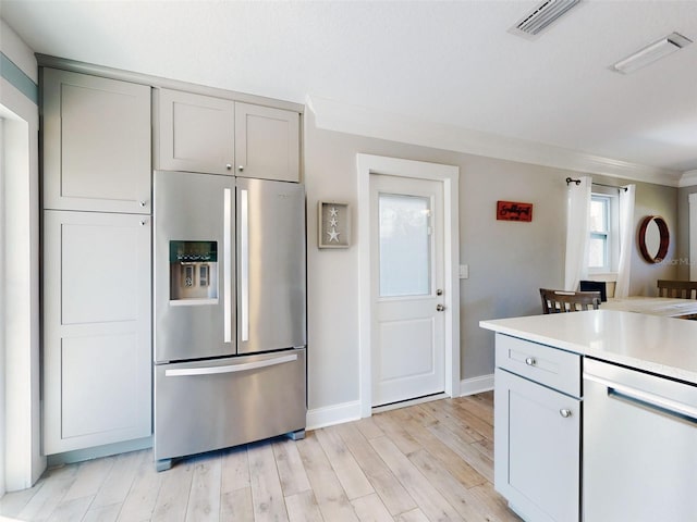 16 Hillside Dr, New Smyrna Beach, FL 32169 - kitchen with stainless steel fridge with ice dispenser, light wood-style flooring, visible vents, gray cabinets, and light countertops