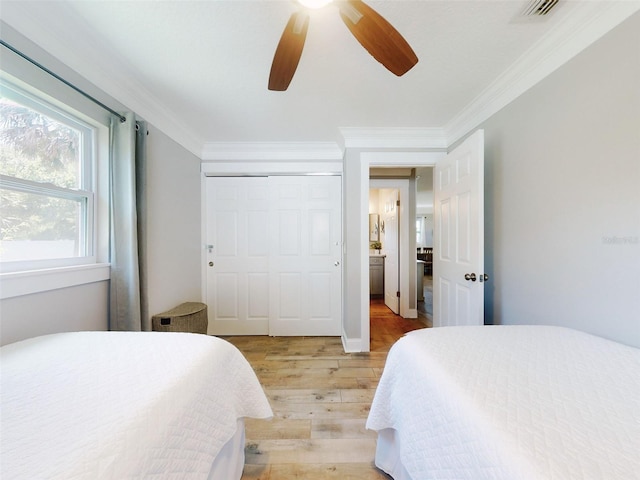16 Hillside Dr, New Smyrna Beach, FL 32169 - bedroom with ornamental molding, light wood-style flooring, ceiling fan, and visible vents