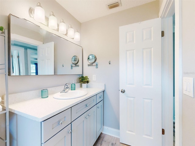 16 Hillside Dr, New Smyrna Beach, FL 32169 - bathroom with visible vents, baseboards, vanity, and wood finished floors