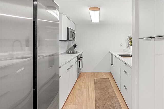 705 N Atlantic Ave Unit 4030, New Smyrna Beach, FL 32169 - kitchen with stainless steel appliances, light countertops, white cabinetry, light wood-type flooring, and modern cabinets