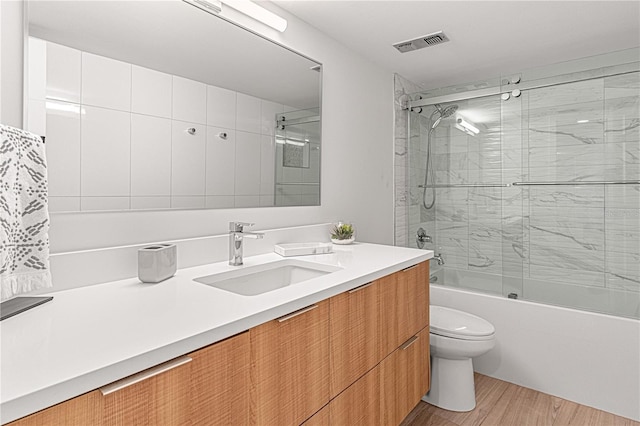 705 N Atlantic Ave Unit 4030, New Smyrna Beach, FL 32169 - bathroom with bath / shower combo with glass door, visible vents, toilet, wood finished floors, and vanity