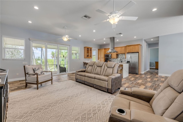 living room featuring a ceiling fan, visible vents, and recessed lighting