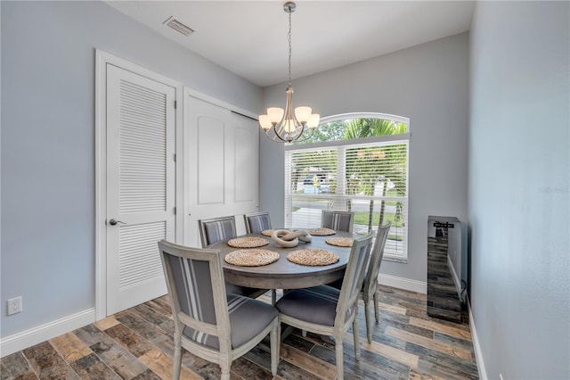 dining area with baseboards, a chandelier, heating unit, dark wood-type flooring, and visible vents