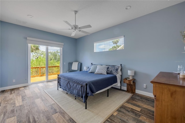 bedroom with access to exterior, wood finished floors, baseboards, and multiple windows