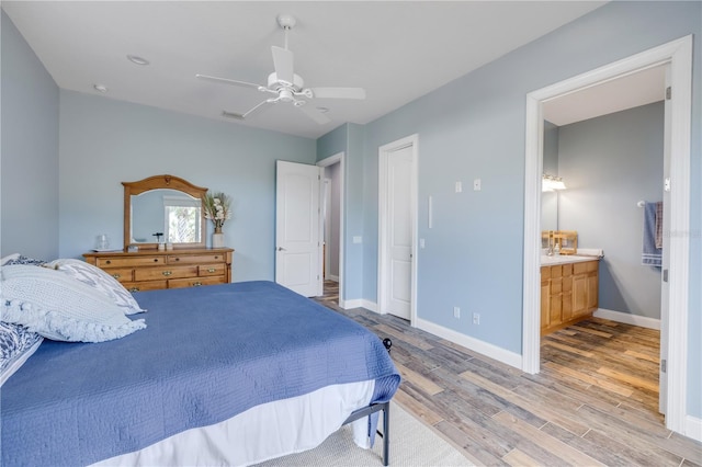 bedroom with ceiling fan, light wood-type flooring, ensuite bath, visible vents, and baseboards
