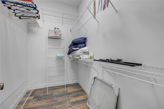 walk in closet with wood finished floors