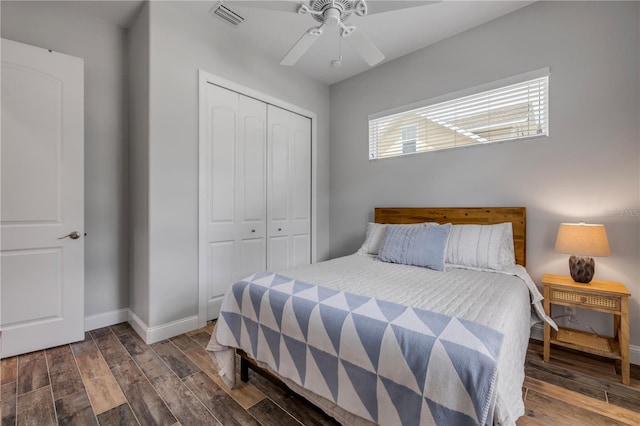 bedroom featuring visible vents, baseboards, a closet, and wood finished floors