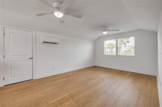 spare room with light wood-style floors, a wall mounted air conditioner, ceiling fan, and vaulted ceiling