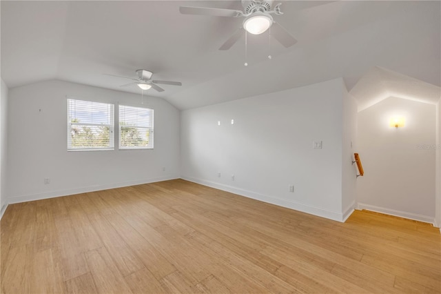 unfurnished room featuring baseboards, light wood-type flooring, a ceiling fan, and lofted ceiling