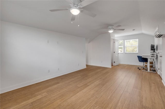 interior space featuring light wood-style floors, a ceiling fan, vaulted ceiling, and an AC wall unit