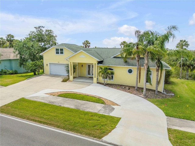 view of front of property with concrete driveway, a garage, and a front lawn