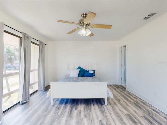 4752 S Atlantic Ave Unit 1, Ponce Inlet, FL 32127 - bedroom with multiple windows, light wood-type flooring, a ceiling fan, and access to outside