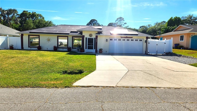 ranch-style house with roof mounted solar panels, stucco siding, a front yard, an attached garage, and concrete driveway