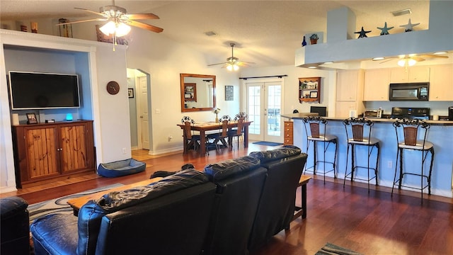 living area featuring french doors, dark wood-style flooring, and a ceiling fan