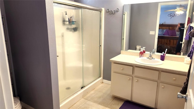 ensuite bathroom with ensuite bathroom, tile patterned floors, a stall shower, and vanity