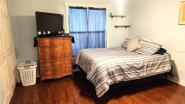 bedroom featuring baseboards and dark wood finished floors