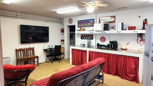 interior space with light colored carpet, a ceiling fan, and a textured ceiling