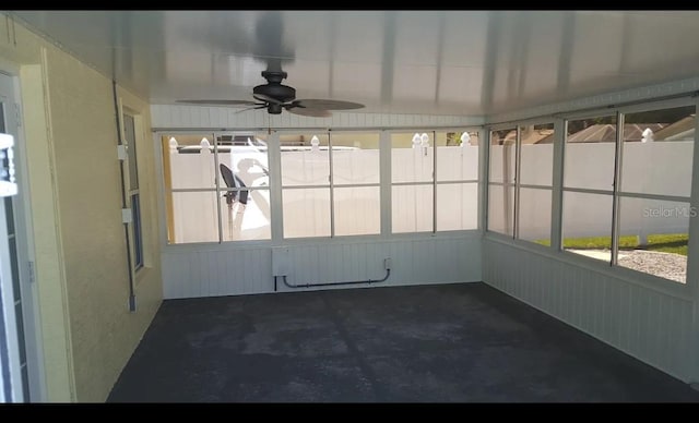 unfurnished sunroom featuring radiator heating unit and a ceiling fan