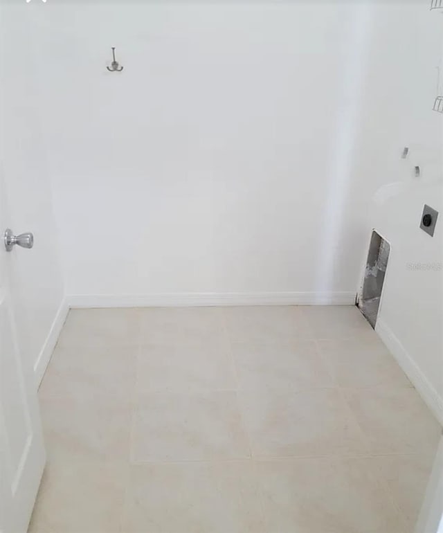 washroom featuring light tile patterned floors, baseboards, electric dryer hookup, and laundry area