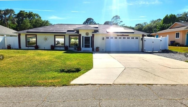 2820 Tamarind Dr, Edgewater, FL 32141 - ranch-style house with a garage, concrete driveway, solar panels, stucco siding, and a gate