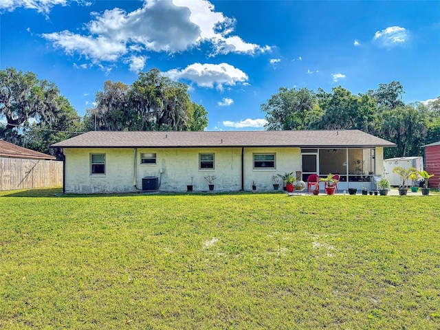 2218 Orange Tree Dr, Edgewater, FL 32141 - rear view of house with a sunroom, central AC unit, fence, and a lawn
