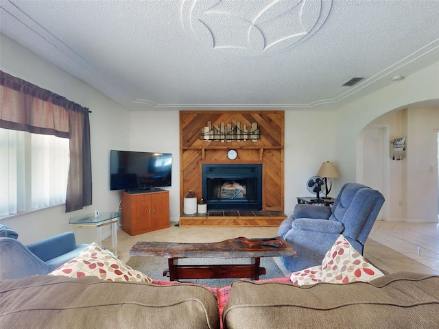 2218 Orange Tree Dr, Edgewater, FL 32141 - living room featuring arched walkways, a textured ceiling, visible vents, and a fireplace