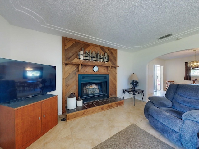 2218 Orange Tree Dr, Edgewater, FL 32141 - tiled living area featuring a fireplace, visible vents, arched walkways, and a textured ceiling