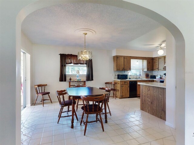2218 Orange Tree Dr, Edgewater, FL 32141 - dining area with ceiling fan with notable chandelier, arched walkways, a textured ceiling, and light tile patterned floors