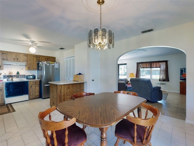 2218 Orange Tree Dr, Edgewater, FL 32141 - dining space with ceiling fan with notable chandelier, visible vents, arched walkways, and light tile patterned floors