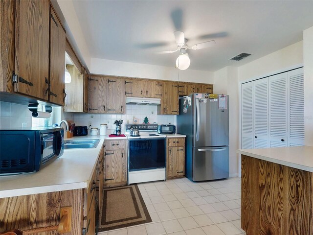 2218 Orange Tree Dr, Edgewater, FL 32141 - kitchen featuring range with electric cooktop, a sink, visible vents, freestanding refrigerator, and under cabinet range hood
