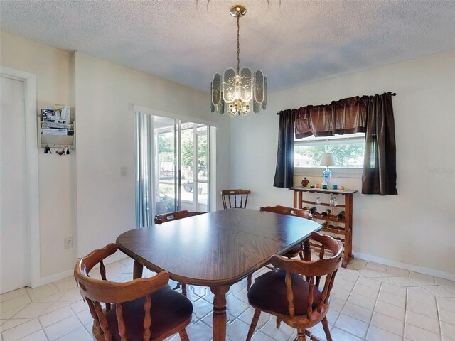 2218 Orange Tree Dr, Edgewater, FL 32141 - dining area featuring a notable chandelier, a textured ceiling, and light tile patterned floors