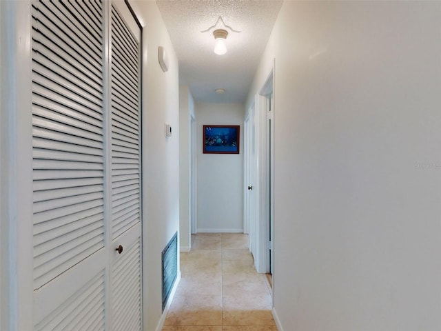2218 Orange Tree Dr, Edgewater, FL 32141 - hall featuring baseboards, a textured ceiling, visible vents, and light tile patterned floors