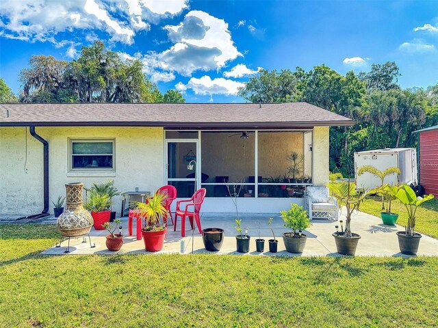 2218 Orange Tree Dr, Edgewater, FL 32141 - rear view of property with a yard, a sunroom, a patio, and stucco siding