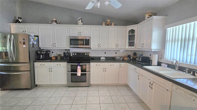 2530 Tamarind Dr, Edgewater, FL 32141 - kitchen featuring stainless steel appliances, a sink, vaulted ceiling, white cabinets, and light tile patterned floors