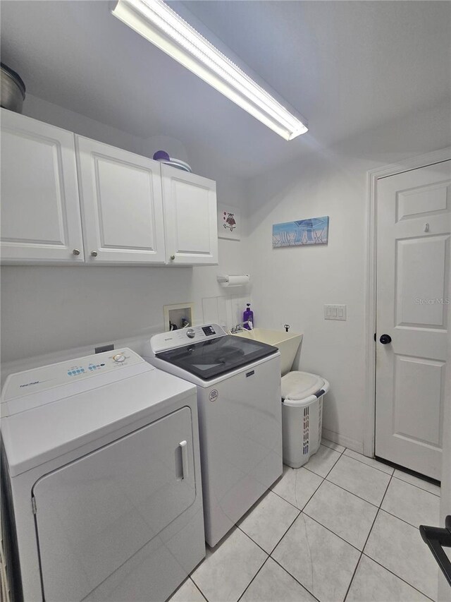 2530 Tamarind Dr, Edgewater, FL 32141 - laundry area with cabinet space, washing machine and clothes dryer, and light tile patterned floors