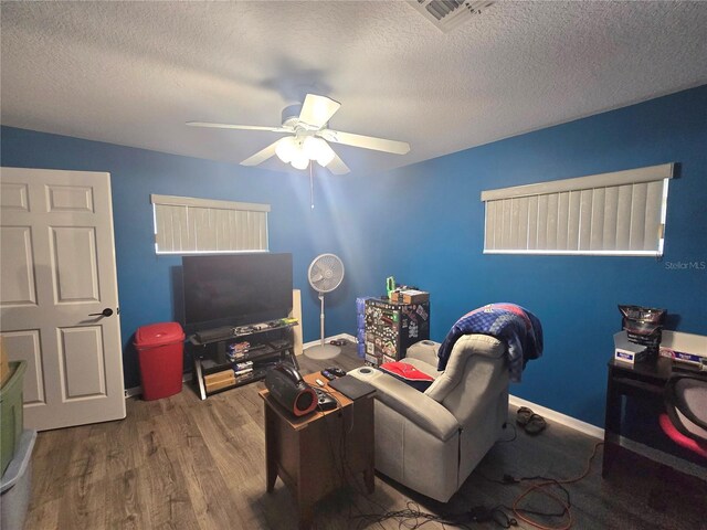 2530 Tamarind Dr, Edgewater, FL 32141 - living room featuring wood finished floors, a ceiling fan, a textured ceiling, and baseboards