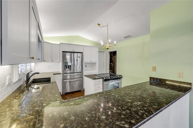 606 Saint Andrews Blvd, New Smyrna Beach, FL 32168 - kitchen with lofted ceiling, stainless steel appliances, an inviting chandelier, a sink, and a peninsula