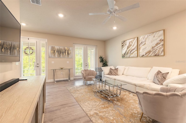 living room with french doors, light wood finished floors, baseboards, visible vents, and recessed lighting
