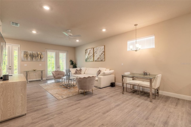 living room with recessed lighting, baseboards, ceiling fan with notable chandelier, and light wood-type flooring