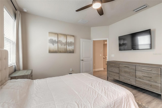 bedroom featuring wood finished floors, visible vents, and ceiling fan