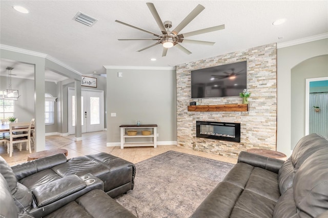 495 Venetian Villa Dr, New Smyrna Beach, FL 32168 - tiled living room with visible vents, baseboards, ornamental molding, a ceiling fan, and a fireplace
