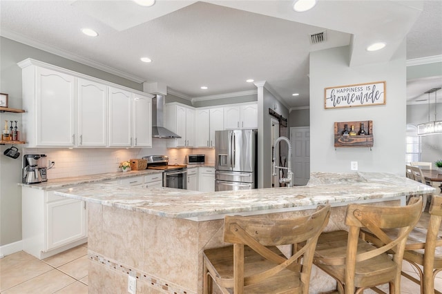 495 Venetian Villa Dr, New Smyrna Beach, FL 32168 - kitchen with ornamental molding, wall chimney range hood, a peninsula, visible vents, and appliances with stainless steel finishes