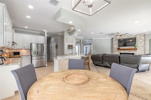 495 Venetian Villa Dr, New Smyrna Beach, FL 32168 - dining space with a large fireplace, ornamental molding, visible vents, recessed lighting, and light tile patterned flooring