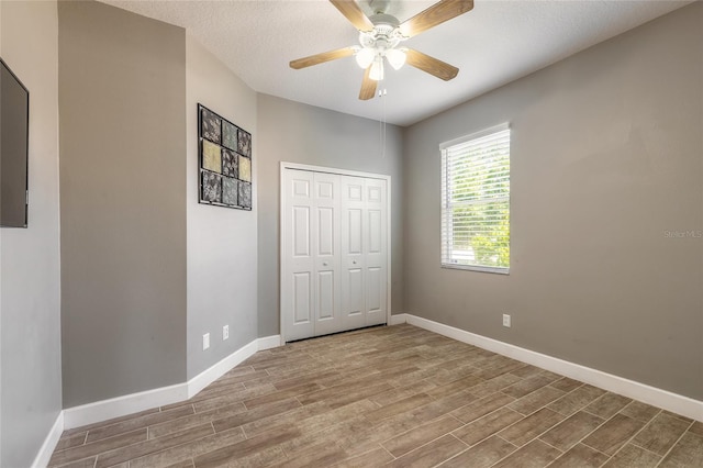 495 Venetian Villa Dr, New Smyrna Beach, FL 32168 - unfurnished bedroom with a closet, baseboards, ceiling fan, and wood finished floors