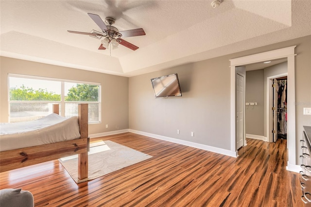 495 Venetian Villa Dr, New Smyrna Beach, FL 32168 - bedroom with baseboards, wood finished floors, a ceiling fan, and a raised ceiling