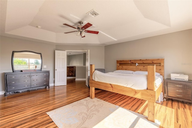 495 Venetian Villa Dr, New Smyrna Beach, FL 32168 - bedroom with baseboards, a ceiling fan, visible vents, a raised ceiling, and wood finished floors